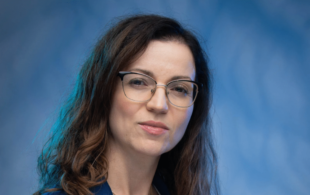 Agnieszka Daniło na niebieskim tle w okularach